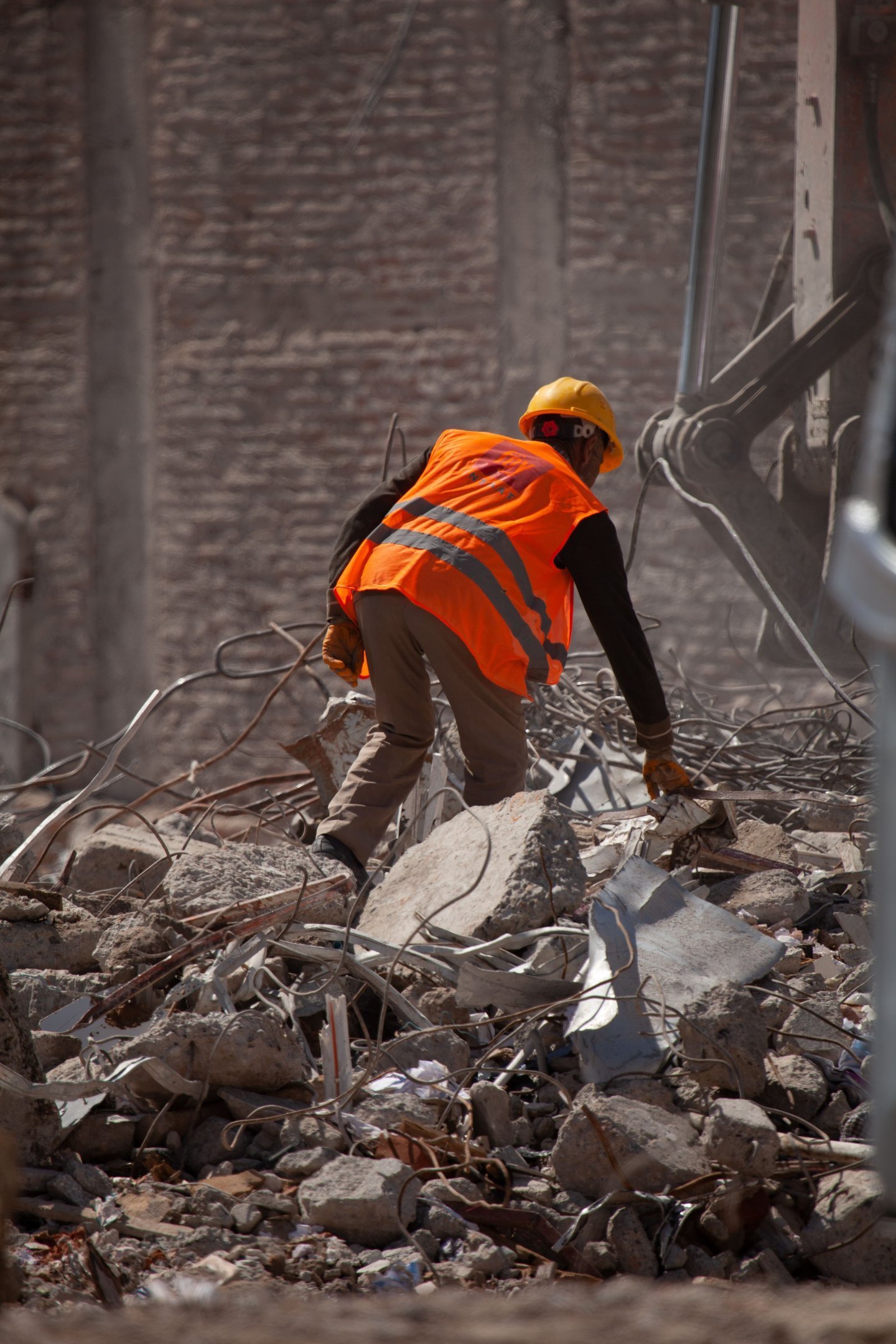 Worker in a hard hat and high-visibility vest on a demolition site